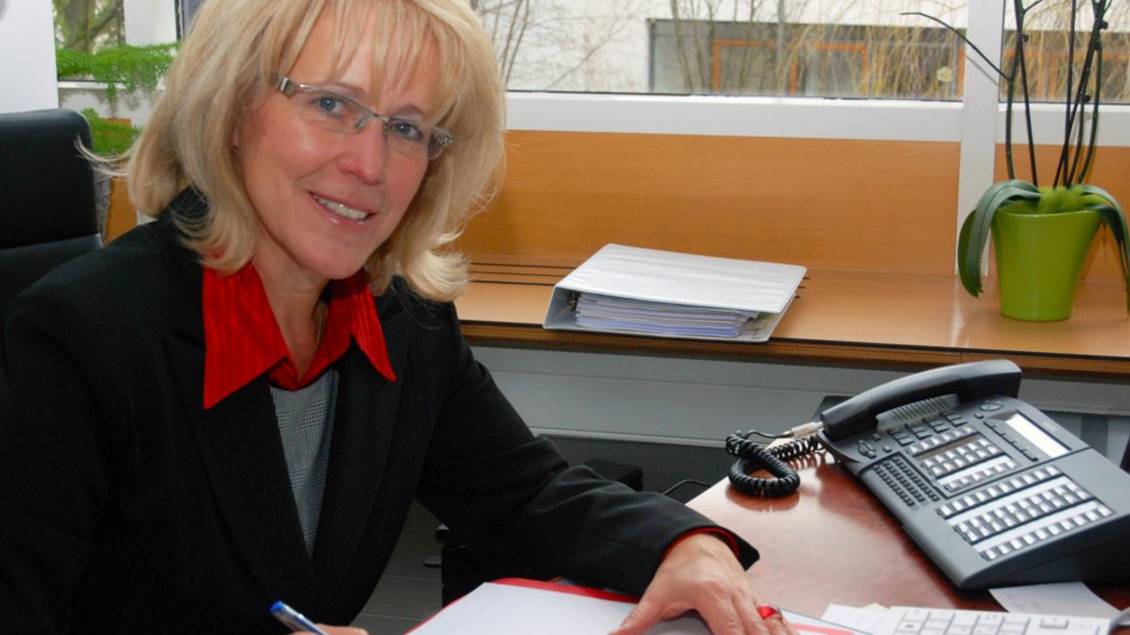Das Foto zeigt eine Frau an einem Tisch.