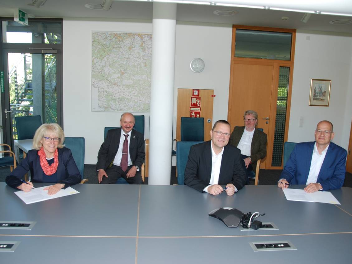 Das Foto zeigt mehrere Personen an einem Tisch.