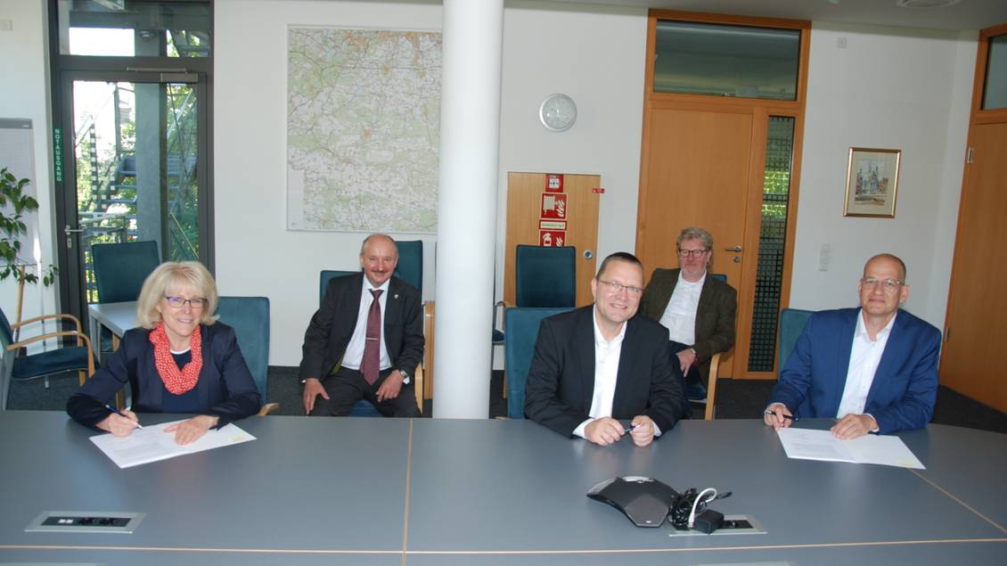 Das Foto zeigt mehrere Personen an einem Tisch.