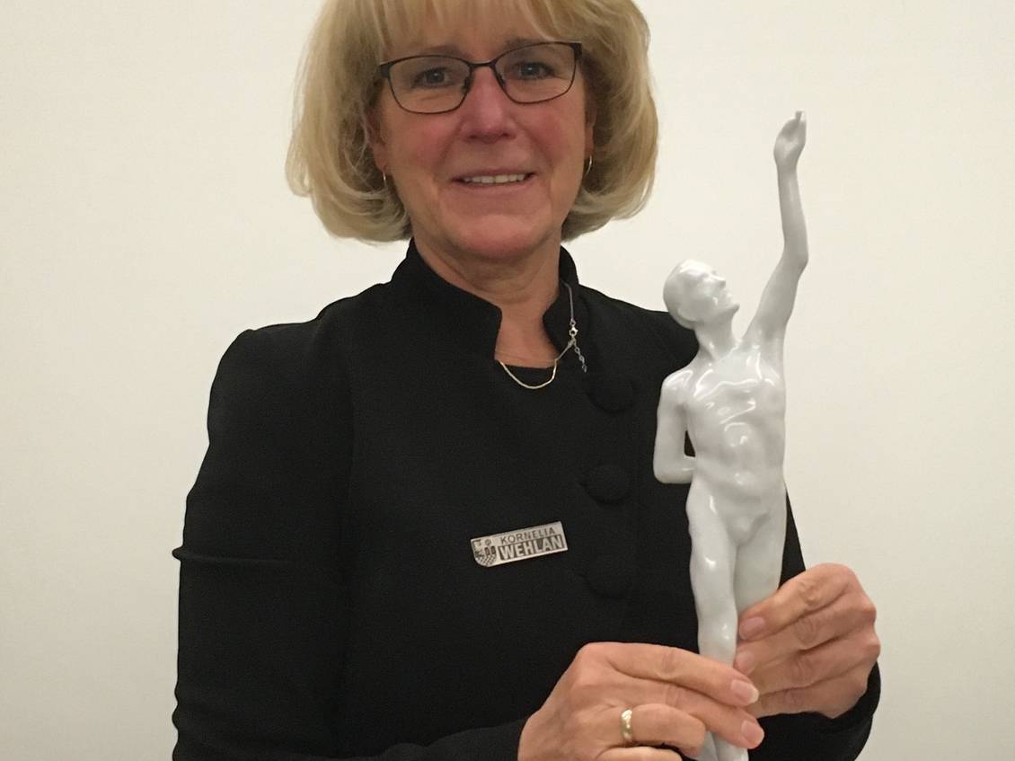 Das Foto zeigt eine Frau, die eine Porzellanfigur hält.