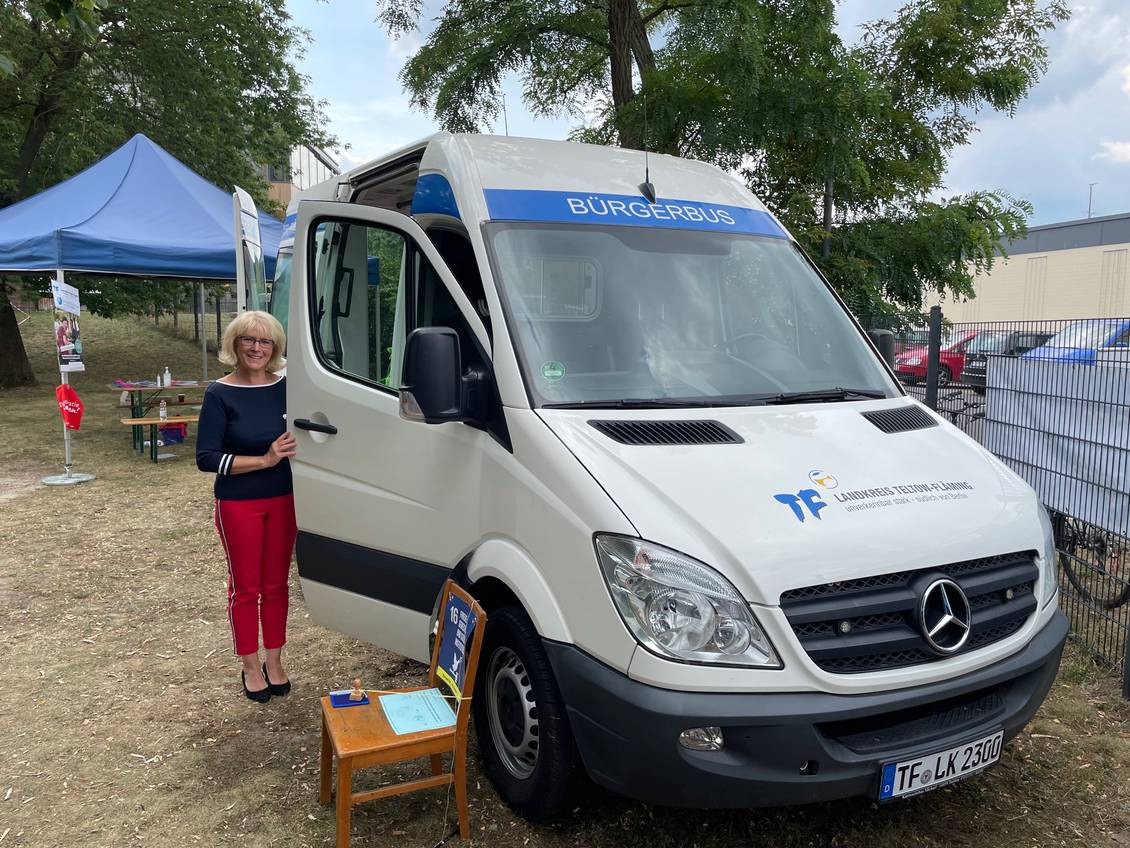 Das Foto zeigt eine Frau an einem Fahrzeug.
