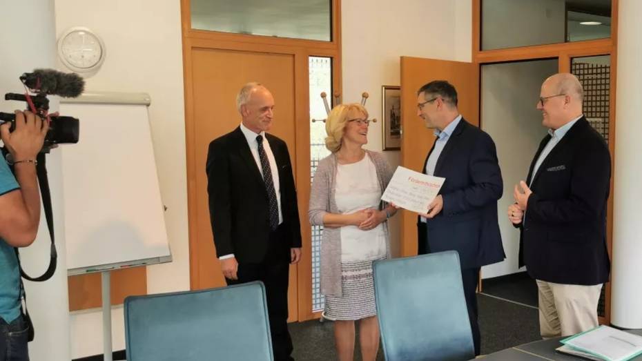 Das Foto zeigt mehrere Personen bei der Förderscheck-Übergabe.