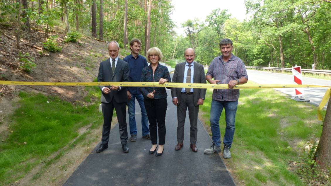Das Foto zeigt eine Gruppe von Personen beim Durchschneiden eines Bandes.