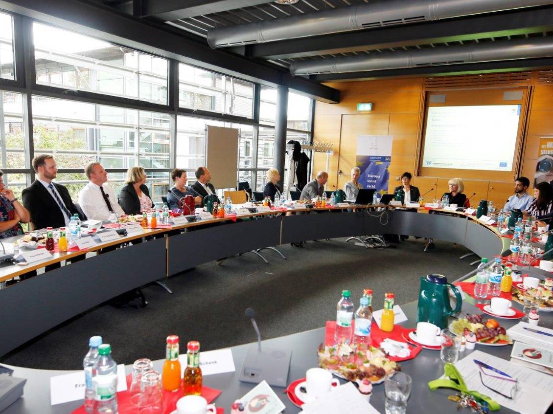 Das Foto zeigt eine Gruppe von Personen im Sitzungssaal des Kreishauses.