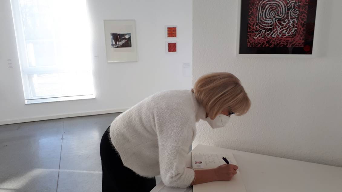 Das Foto zeigt eine Frau an einem Tisch.