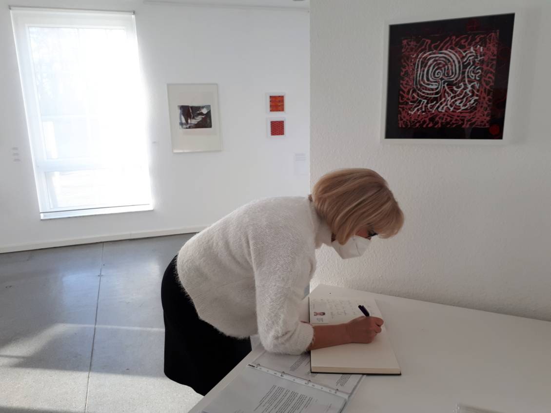 Das Foto zeigt eine Frau an einem Tisch.