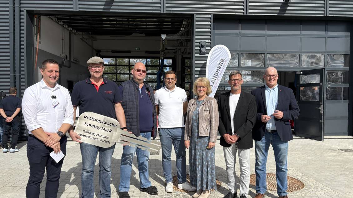 Das Foto zeigt mehrere Personen vor der neuen Rettungswache in Dahme/Mark ,eine Person hält einen symbolischen Schlüssel.