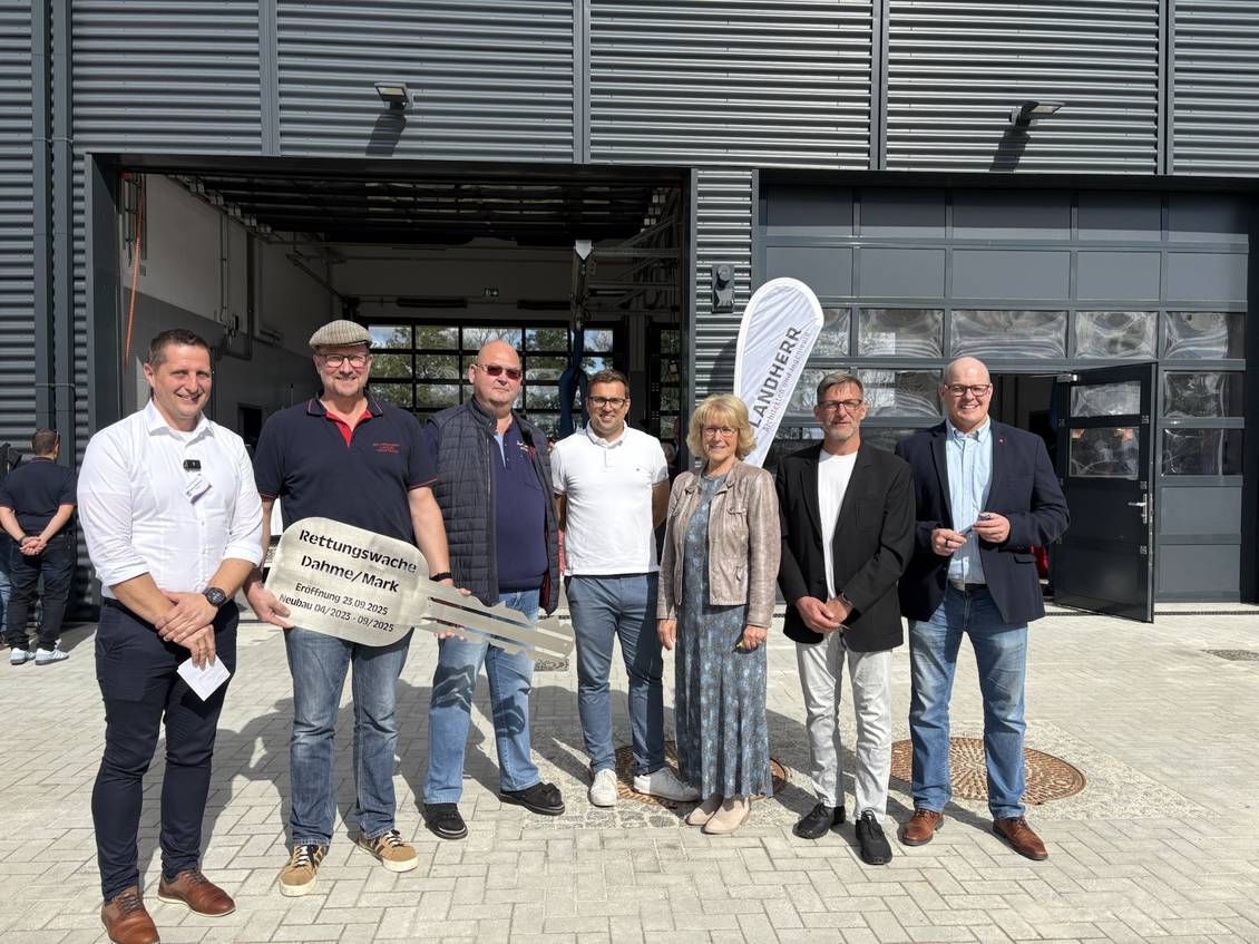 Das Foto zeigt mehrere Personen vor der neuen Rettungswache in Dahme/Mark ,eine Person hält einen symbolischen Schlüssel.